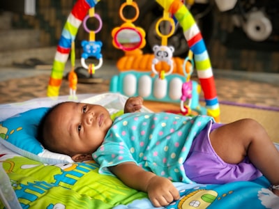bébé noir allongé sur un tapis d'éveil
